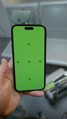 Kalabalık Havalimanı Terminali: POV Adam Yeşil Krom Anahtarlı Cep Telefonu ile Ayrılış Salonunda Bekliyor. İş Reklamcılığı için video şablonu. Birinci Şahıs Görünümü. Dikey Çekim.