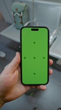Kalabalık Havaalanı Terminali: POV Adam Yeşil Kroma Anahtarlı Akıllı Telefonu Bekleme Salonu 'nda duruyor. Sosyal medya içeriği için video şablonu. Birinci Şahıs Görünümü. Dikey Çekim.