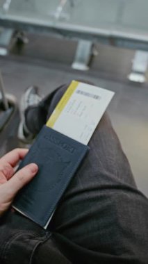 Kalabalık Uluslararası Havaalanı Terminali: Bavul, Pasaport ve Uçak Biletli Yolcu Kalkış Salonunda Oturuyor, Sonra Biniş için Kapıya Yürüyor. POV Birinci Şahıs Görünümü. Dikey Çekim.