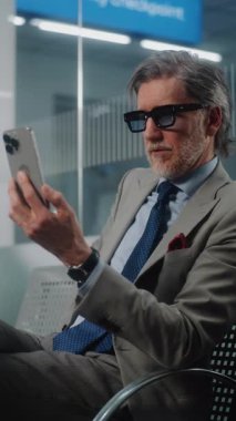 Havaalanı Terminali: Başarılı İşadamı Smartphone 'da İş Ortağıyla Konuşuyor, Video Call, Oturma Salonu. Girişimci Uçuşu Bekliyor, Seyahate Çıkıyor. Yavaş Hareket Dikey Çekim