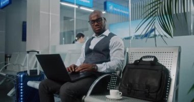 Uluslararası Havalimanı Terminali: Laptop kullanan, kahve içen, e-posta gönderen Afro-Amerikan İşadamı. Girişimci Çevrimiçi Çalışan Ayrılış Salonunda Uçuş Bekliyor. Doli Vuruşu.