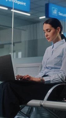 Havaalanı Terminali: Başarılı İşkadını Laptop Kullanıyor, Çevrimiçi Çalışıyor ve Gidiş Salonunda Uçak Beklerken E- posta Gönderiyor. Kadın Girişimci İş Gezisine Gidiyor. Dikey Çekim
