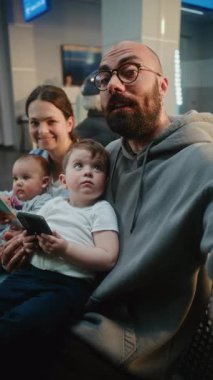 Kalabalık Havaalanı Terminali: Popüler Blogger Smartphone Kullanarak Seyahat Vlog 'unu çekiyor, Kalkış Salonunda Uçuşu Bekliyor. Seyahat Blog 'u için video içeriği, video çağrısı. Dikey Çekim