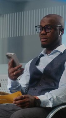 Havaalanı Terminali: Afrikalı Amerikalı Girişimci Gecikmeli Uçuş Tutma Uçak Bileti Hakkında Rahatsız Oldu, Telefonda Konuşuyor. İş adamı, Ayrılış Salonu 'nda oturuyor, iş gezisine çıkıyor. Dikey Çekim