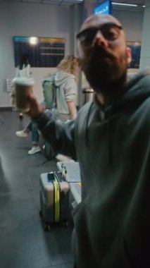 Kalabalık Havalimanı Terminali: Popüler Blogger, Influencer Vlog from Tatil Gezisi Akıllı Telefon Kullanıyor, Uçuş için Bekleme Salonu. Seyahat Blog 'u için video içeriği, video çağrısı. Dikey Çekim