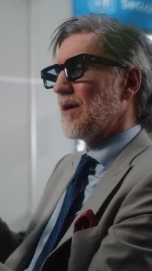 Havaalanı Terminali: Başarılı Girişimci Akıllı Telefondan Yatırımcıyla Konuşuyor, Video Sohbet, Kahve İçme. İş adamı kalkış salonunda uçuşu bekliyor, iş gezisine çıkıyor. Dikey Çekim.