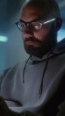 Kalabalık Uluslararası Havaalanı Terminali: Yorgun ve Uykucu Adam Tablet Bilgisayar Kullanıyor, Gece Oturma Salonu 'nda. Çeşitli Yolcular ve Gezginler Gecikmeli Uçuşu Bekliyor. Dikey Çekim.