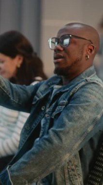 Kalabalık Uluslararası Havalimanı Terminali: Afro-Amerikan Seyahat Blogcusu Akıllı Telefon Kullanarak Seyahat Gezisinden Video İçeriği. Ayrılış Salonunda Uçuşu Bekleyen Çeşitli İnsanlar. Dikey Çekim.