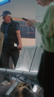 Havaalanı Terminali: Kalabalık Havayolu Merkezinin Biniş Salonundaki Çeşitli İnsanlar ve Yolcular. Pasaport kontrolünden sonra sırt çantalı yorgun yaşlı adam uçak uçuşunu bekliyor. Dikey Çekim.