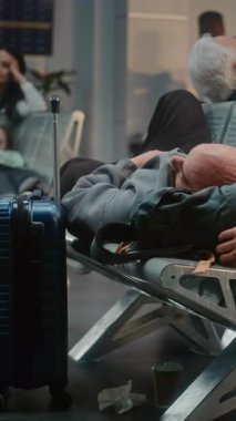 Kalabalık Uluslararası Havaalanı Terminali: Yatılı Salondaki Koltuklarda Uyuyan Yorgun Adam. Çeşitli İnsanlar ve Yolcular Gecikmeli Uçuşu Bekliyor. Dolly yakınlaştır. Dikey Çekim