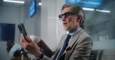 Havaalanı Terminali: Başarılı Girişimci Akıllı Telefondan Yatırımcıyla Konuşuyor, Video Sohbet, Kahve İçme. İş adamı kalkış salonunda uçuşu bekliyor, iş gezisine çıkıyor. Ortam Kapalı.