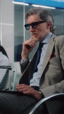 Havaalanı Terminalinden VIP Gidiş Salonu: Olgun İşadamı Laptop Kullanıyor, E-posta Gönderiliyor. Uçuşu Bekleyen Dijital Aygıtlarla çalışan çeşitli iş adamları. Dolly Shot. Dikey Çekim.