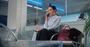 Uluslararası Havalimanı Terminali: Sinirli İş Kadını Cep Telefonuyla Konuşuyor, Uçak Kalkış Salonunda Uçak Uçuşunu Bekliyor. Kadın Girişimci İş Gezisine Gidiyor. El bilgisayarı.
