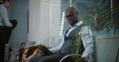 Havaalanı Terminali: Başarılı Girişimci Dijital Tablet Kullanıyor, Kahve İçiyor. Afrika kökenli Amerikalı iş adamı, kalkış salonunda uçak bekliyor, iş gezisine çıkıyor. Yavaş Hareket, Orta Çekim.