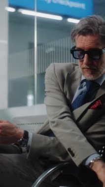 Havaalanı Terminali: Dijital Tablet ve İçme Kahvesi kullanan başarılı girişimci, e-iş yapıyor. İşadamı Uzaktan Çalışmalar Çevrimiçi Ayrılış Salonunda Uçuş Bekliyor. Yavaş Hareket, Dikey Çekim.