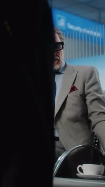 Havaalanı Terminali: Laptop ve Smartphone kullanan başarılı iş adamı, e-posta gönderiyor. Olgun Girişimci Çevrimiçi Çalışan Ayrılış Salonunda Uçuş Bekliyor. Ağır çekim. Dikey Çekim.