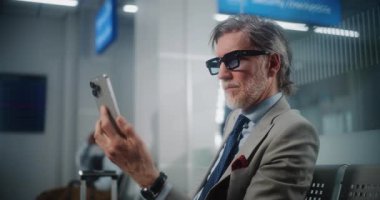 Havaalanı Terminali: Başarılı İşadamı Smartphone 'da İş Ortağıyla Konuşuyor, Video Call, Oturma Salonu. Girişimci Uçak Uçuşunu Bekliyor, Seyahate Çıkıyor. Ortam Kapalı.