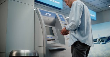 Kalabalık Havalimanı Terminali 'ndeki Cash Machine: ATM' nin tuşlarına basan adam, şifre girişi, para çekme, para çekme. Otomatik veznedar makinesi, bankacılık hizmetleri, işlemler. Orta Çekim.