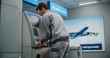 Modern Havalimanı Terminalindeki ATM 'de teknisyen. Otomatik Teller Machine 'in iç bileşenlerini tamir eden üniformalı bir erkek işçi. Bankacılık ve Para Çekme Sistemleri. Sabit Çekim