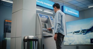 Kalabalık Havalimanı Terminali 'ndeki ATM Makinesi: ATM Klavyesinde Adam Basma Tuşları, Para Çekme Operasyonu için Şifre Girme, Nakit Alma. Para makinesi, banka hizmetleri ve işlemler. Orta Çekim