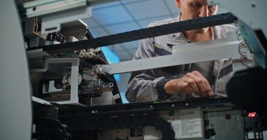 Modern Havalimanı Terminalindeki ATM 'de teknisyen. Otomatik Teller Machine 'in iç bileşenlerini tamir eden üniformalı bir erkek işçi. Bankacılık ve Para Çekme Sistemleri. Kapat..