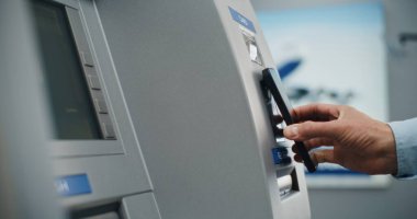 Havalimanı Terminalindeki ATM Makinesi: Bilinmeyen Kişinin Yakın Çekimi NFC okuyucusuna Temassız Para Çekme Operasyonu için Smartphone koydu. Para Makinesi, Banka Hizmetleri ve Aktarımlar.