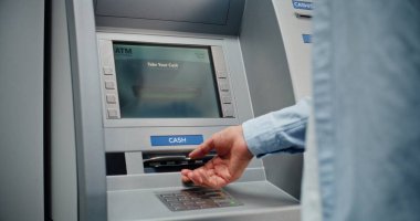 ATM Makinesi: Tanınmayan Adam PIN kodunu klavyeye giriyor, para çekme işlemini seçiyor, Miktarı giriyor ve nakit dağıtıcıdan Amerikan Doları alıyor. Banka Sistemi ve Operasyonlar. Kapat..
