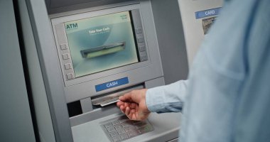 Cash Machine: Tanınmayan Adam Klavyeden PIN kodunu giriyor, Para çekme operasyonunu seçiyor, Miktar 'a giriyor ve ATM' den Amerikan Doları alıyor. Bankacılık ve İşlemler. Kapat..