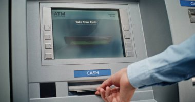 Cash Machine: Tanınmayan Adam Klavyeden PIN kodunu giriyor, Para çekme operasyonunu seçiyor, Miktar 'a giriyor ve ATM' den Amerikan Doları alıyor. Bankacılık ve İşlemler. Kapat..