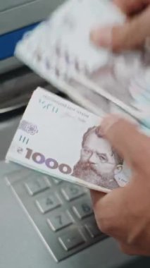 Tanınmayan Adam 'ın Kapanışı, ATM' den para çektikten sonra İşadamı Hryvnia Faturalarını Sayıyor. Bankacılık, nakit para çekme, finansal işlemler. Dikey Çekim.