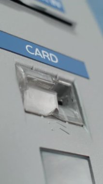 Havalimanı Terminali 'ndeki ATM Makinesi: Tanınmayan Kişinin Yakın Çekimi Plastik veya Kredi Kartını Para Çekme Operasyonuna Eklemek. Para makinesi, banka hizmetleri. Dikey Çekim.