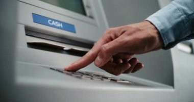 ATM 'de tanınmayan kullanıcı tuşlarına basıyor, para çekmek için PIN' e giriyor, para alıyor. Otomatik veznedar, para makinesi. Banka Hizmetleri ve Operasyonlar. Kapat.
