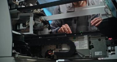 Modern Havalimanı Terminalindeki ATM 'de teknisyen. Otomatik Teller Machine 'in iç bileşenlerini tamir eden üniformalı bir erkek işçi. Bankacılık ve Para Çekme Sistemleri. Kapat..