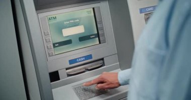 Cash Machine: Tanınmayan Adam Klavyeden PIN kodunu giriyor, Para çekme operasyonunu seçiyor, Miktar 'a giriyor ve ATM' den Amerikan Doları alıyor. Bankacılık ve İşlemler. Kapat..