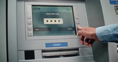 Cash Machine: Tanınmayan Adam Klavyeden PIN kodunu giriyor, Para çekme operasyonunu seçiyor, Miktar 'a giriyor ve ATM' den Amerikan Doları alıyor. Bankacılık ve İşlemler. Kapat..