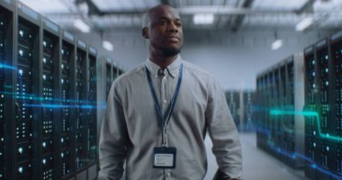 VFX ile Fütürist Büyük Veri Merkezi 'nde Dijital Tablet Yürüyüşü yapan Afrikalı Amerikalı Yönetici. Sunuculardaki İnternet Trafiğinin Animasyon Diyagramları. Bilgi Teknolojisi, Dijitalleştirme Konsepti.