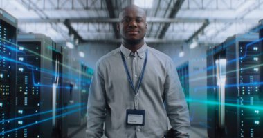 VFX ile Fütürist Büyük Veri Merkezi 'nde Dijital Tablet Yürüyen Afrikalı Amerikalı Yönetici, Kameraya Bakıyor. Sunuculardaki İnternet Trafiğinin Animasyon Diyagramları. Bilgi Dijitalleştirmesi.