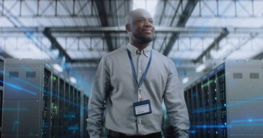 VFX ile Fütürist Büyük Veri Merkezi 'nde Dijital Tablet Yürüyen Afrikalı Amerikalı Yönetici, Kameraya Bakıyor. Sunuculardaki İnternet Trafiğinin Animasyon Diyagramları. Bilgi Dijitalleştirmesi.