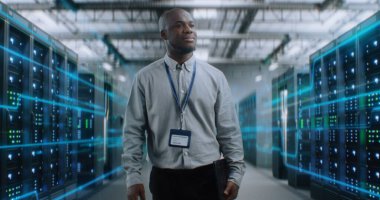 VFX ile Fütürist Büyük Veri Merkezi 'nde Dijital Tablet Yürüyüşü yapan Afrikalı Amerikalı Yönetici. Sunuculardaki İnternet Trafiğinin Animasyon Diyagramları. Bilgi Teknolojisi, Dijitalleştirme Konsepti.