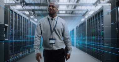 VFX ile Fütürist Büyük Veri Merkezi 'nde Dijital Tablet Yürüyüşü yapan Afrikalı Amerikalı Yönetici. Sunuculardaki İnternet Trafiğinin Animasyon Diyagramları. Bilgi Teknolojisi, Dijitalleştirme Konsepti.