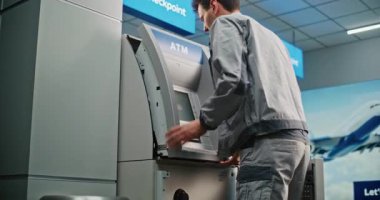 Modern Havalimanı Terminalindeki ATM 'de teknisyen. Otomatik Teller Machine 'in iç bileşenlerini tamir eden üniformalı bir erkek işçi. Bankacılık ve Para Çekme Sistemleri. Doli Vuruşu.