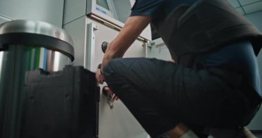 Havalimanı Terminali 'nde ATM Nakit Tahsil Prosedürü uygulayan profesyonel teknisyenler, Para Kasetleri Değiştirme, ATM Hizmeti. Para transferi için nakil operasyonu. El Bilgisayarını Kapat.
