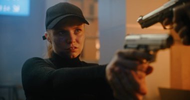 Siyah Taktik Ekipmanlı Kadın Gizli Ajan ve Kaptan Tanımlanamayan Rakip 'e Silahı doğrultup Katille Konuşuyor. Karanlık Ofis Binasında Subay Saldırısı ya da Tutuklama Suçlusu. Eylem Filmi Sahnesi.