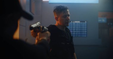 Silahlı Karşılaşma: Taktik Ekipmandaki İki Kızgın Suçlu Birbirlerine Silahlar Nişan Aldılar ve Konuşuyorlar. Karanlık Bina 'da Gangster Saldırısı. Epic Action Movie 'den Gergin ve Dramatik Sahne.