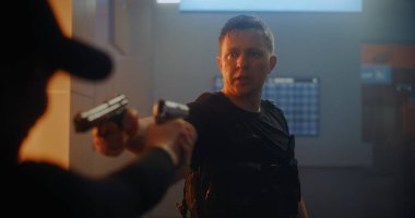 Silahlı Karşılaşma: Taktik Ekipman 'daki iki suçlu birbirine silah doğrultup konuşuyor. Memur Karanlık Ofis Binasında Cinayet Masası 'nda. Epic Action Movie 'den Gergin ve Dramatik Sahne.