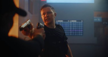 Silahlı Karşılaşma: Taktik Ekipmandaki İki Kızgın Suçlu Birbirlerine Silahlar Nişan Aldılar ve Konuşuyorlar. Karanlık Bina 'da Gangster Saldırısı. Epic Action Movie 'den Gergin ve Dramatik Sahne.