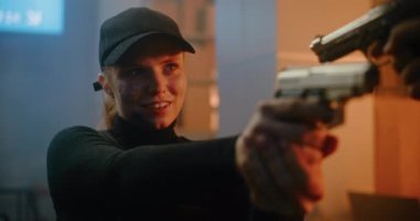 Siyah Taktik Ekipmanlı Kadın Gizli Ajan ve Kaptan Tanımlanamayan Rakip 'e Silahı doğrultup Katille Konuşuyor. Karanlık Ofis Binasında Subay Saldırısı ya da Tutuklama Suçlusu. Eylem Filmi Sahnesi.