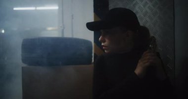 Aksiyon Filmi: Siyah Taktik Giysili Kadın Polis Memuru ve Kaptan Depo 'da Saklanıyor, Silah Tutuyor, Suçluyla Konuşuyor. Ajan Karanlık Bina 'da Saldırmak için Doğru Zaman Bekliyor