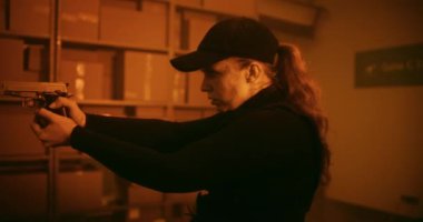 Action Movie Scene: Kadın Taktik Giysi Memuru ve Kaptan Depo 'da Yürüyor, Silah Tutuyor, Pistol ile Tanınamaz Suçluyu Buluyor. Ajan Karanlık Bina 'da Saldırgan. Sıcak. Bak..