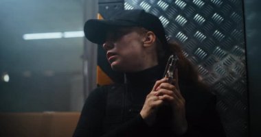 Aksiyon Filmi Sahnesi: Siyah Taktik Giysili Kadın Polis Memuru ve Duvarın Arkasında Saklanan Kaptan, Silah Tutuyor. Ajan Karanlık Ofis Binasında Saldırmak için Doğru Zaman Bekliyor. Kapat..